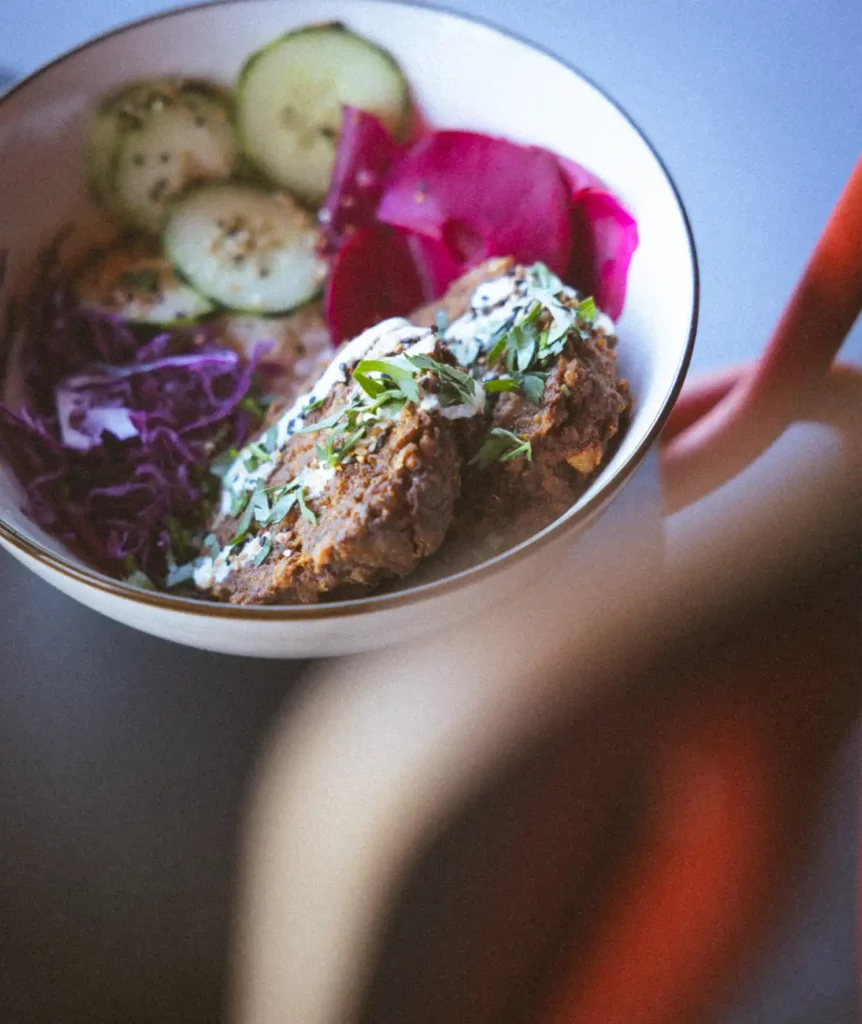 Plat veggie avec concombres, chou rouge et steak vegan chez Choupiquant cantine